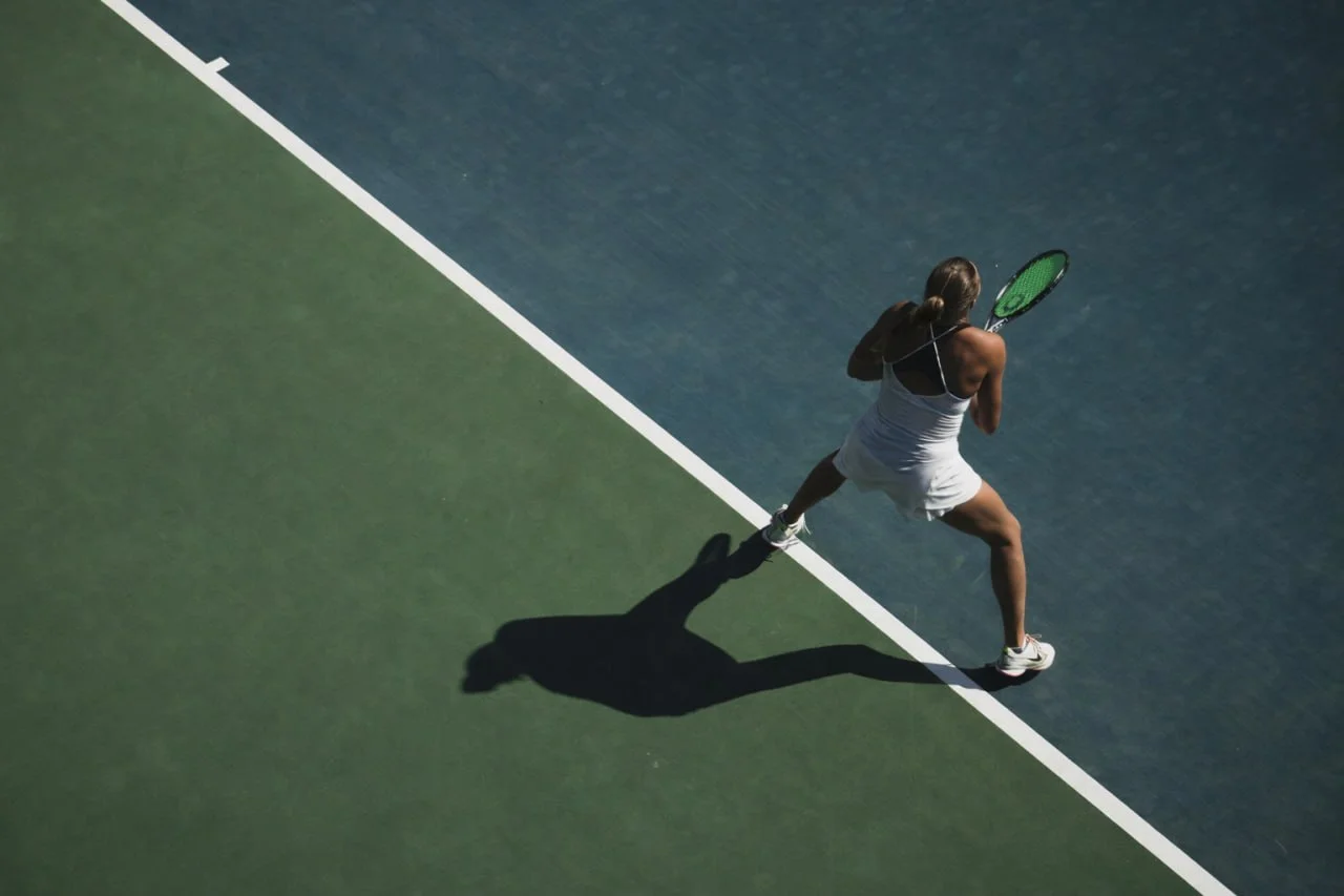 Tennis player mid-swing on court